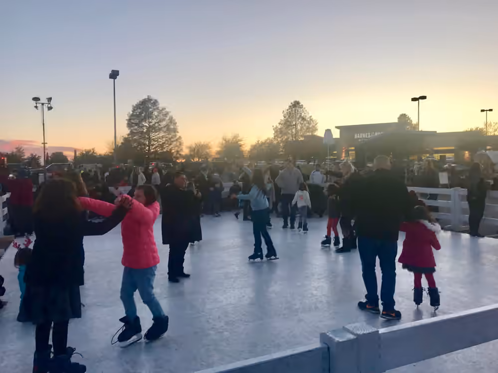 A crowded Classic Holiday rink beneath an evening sky