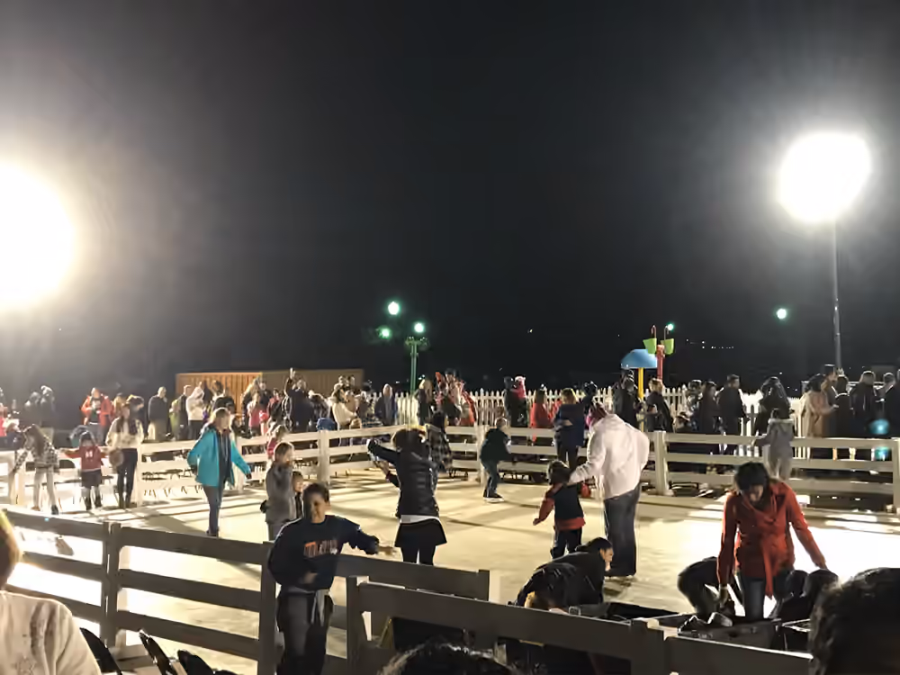 Guests skating under bright event lights at night