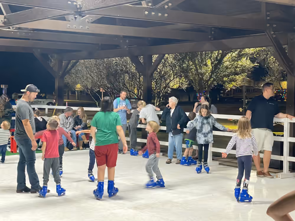 Children and adults skating at a covered community venue