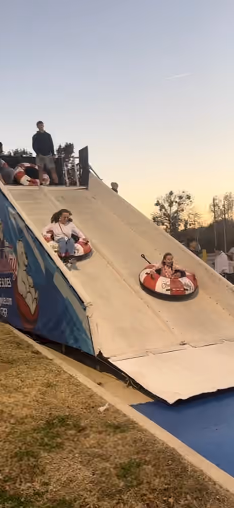 Two guests racing down the dual-lane snow tube slide