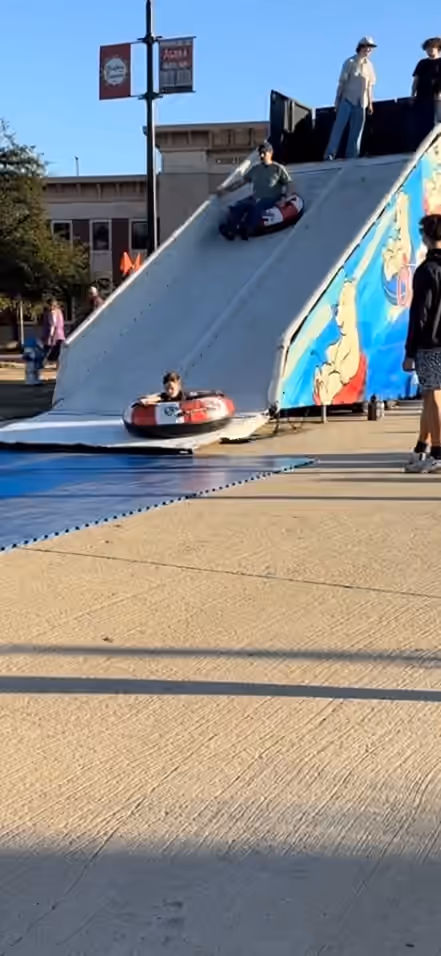 A guest riding down the portable snow tube slide